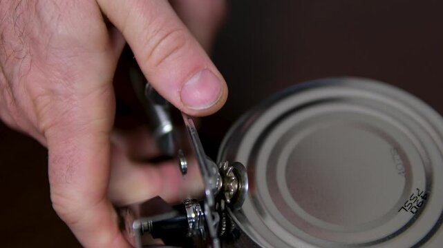 canned pineapple Overhead shot of hands using a tin opener to remove the lid from a can of pineapple chunks. High quality 4k footage