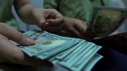 Cute boy at home on sofa in living room count dollar banknotes received from his family. Money for future education. Financial literacy of children. Close-up of cash dollar counting in boy hands. - Powered by Adobe