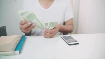shot of human hands counting american dollars. a man counts money on a calculator in his home. Closeup of man hands counting expenses banknotes of dollar cash. Save up budget investment concept. - Powered by Adobe