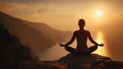 Woman meditating in yoga pose on mountain top at sunrise — mindfulness and nature balance concept