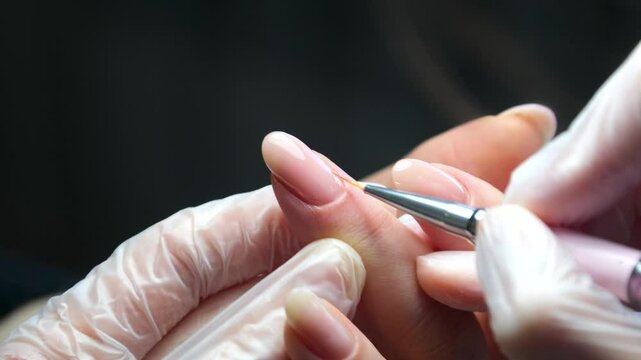 Gel polish manicure step-by-step video tutorial. Nails gel polish. The woman applies the purple gel polish and caps the nail's free edge. Homemade manicure for yourself. High quality 4k footage