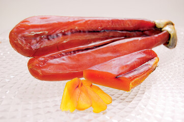 Bottarga, italian delicacy, laying on a transparent glass plate
