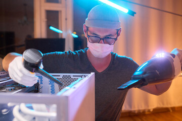 A man cleans a computer case with a vacuum in a bright room, stressing workspace tidiness