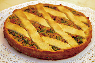 Delicious savory pie with vegetables filling resting on doily
