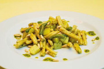 Caserecce pasta with pesto, potatoes, green beans and pine nuts on white plate