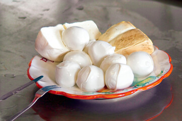Fresh mozzarella and smoked cheese resting on a colorful plate