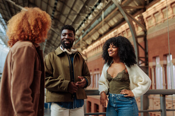 Friends talking and smiling at train station in madrid