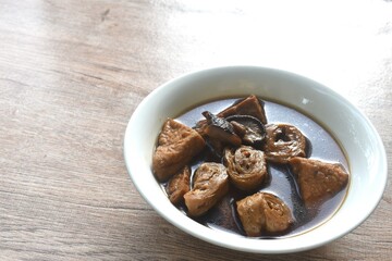 boiled slice tofu and gluten with black mushroom herb soup vegetarian food on bowl