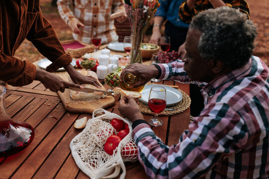 Family and friends enjoying a relaxing outdoor picnic with wine and food