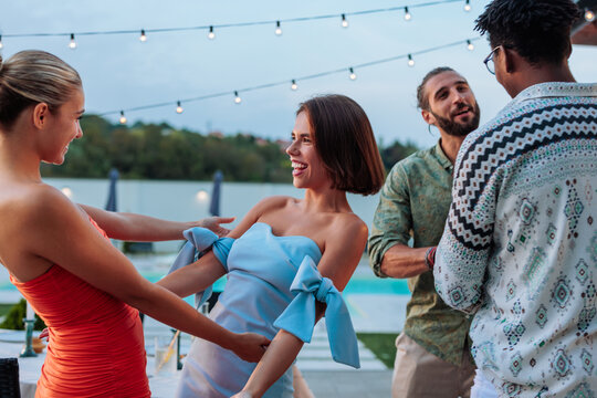 Friends enjoying a pool party, dancing and laughing together - Powered by Adobe