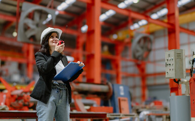 Woman engineer manager standing at steel production factory. Female inspector wears safety hard hat...