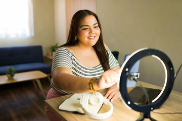 Plus size influencer adjusting ring light before recording video blog