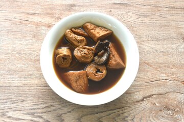 boiled slice tofu and gluten with black mushroom herb soup vegetarian food on bowl