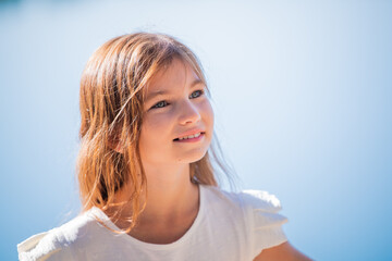 Close up Summer portrait of a happy Caucasian kid with brown hair.