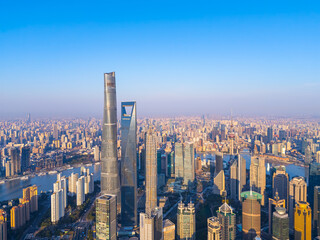 Fototapeta premium Aerial view of Shanghai skyscrapers in downtown with winding river on sunny day.