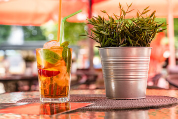 Cold and refreshing orange punch cocktail with slice at the table