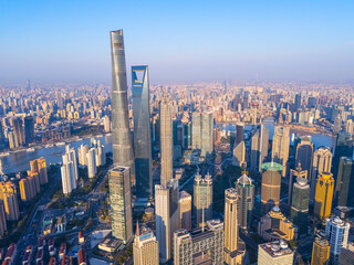 Aerial view of Shanghai skyscrapers in downtown with winding river on sunny day.