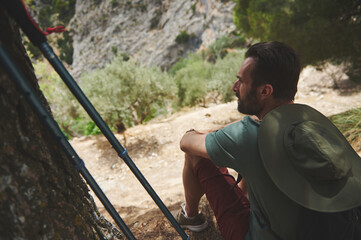 Male Hiker Relaxing With Hiking Gear in a Mountain Forest