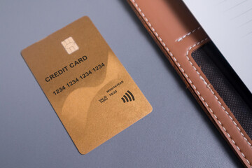 A gold credit card on the desk. Finance transaction or online payment concept.