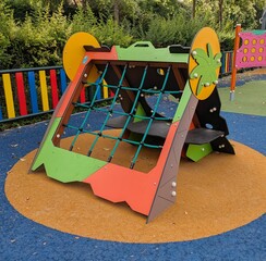 Construcción infantil en parque público. Estructura triangular con red para trepar	