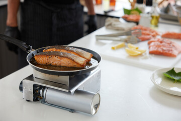 chef cooking salmon steaks in the kitchen