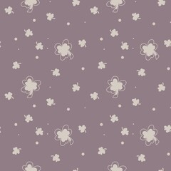 Scattered clovers and playful dots resting on a soft mauve backdrop. Chic minimal clover seamless pattern with simple mauve background. 