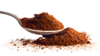 Ground coffee on a spoon spilling onto a pile