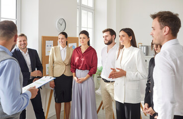 Group of business people standing in a circle discussing job and work projects in office on a...