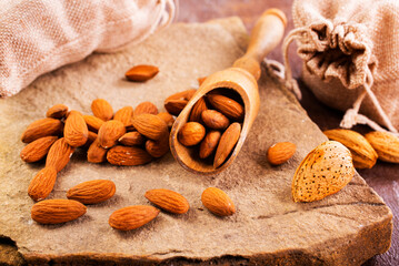 Fragrant roasted almonds with kitchen utensils on a stone table