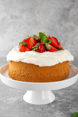 Vanilla sponge cake with whipped cream and fresh strawberries. Summer cake. Selective focus
