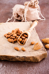 Fragrant roasted almonds with kitchen utensils on a stone table