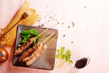 Grilled Lula kebab on skewers with spices in a claim plate on a table