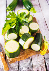 Slicing zucchini on a cutting board. Ripe zucchini. Top view, horizontal.