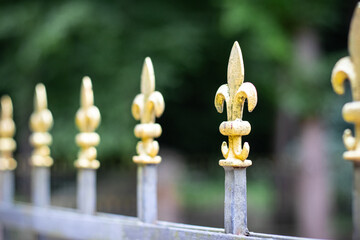 Element metal fence with decorative golden finials in form of crosses and fleurs-de-lis adding...