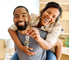 Portrait of a young couple unpacking, holding apartment keys, moving in and relocation to a new...