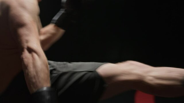 Two martial artists delivering strong kicks during high-energy sparring match, both fighters equipped with boxing gloves and focus