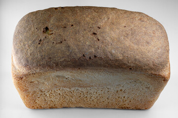 Freshly baked whole grain bread with a rustic crust displayed on a neutral background
