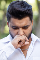 Unwell South Asian young adult man suffering from cold or flu with allergic runny nose, nasal viral infection, dust allergy with inflammatory symptoms, air pollution, bad smell, stinky pungent smell