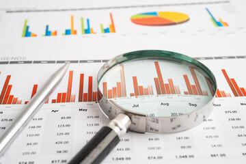 Magnifying glass on spreadsheet and graph paper. Financial data economy, Business.