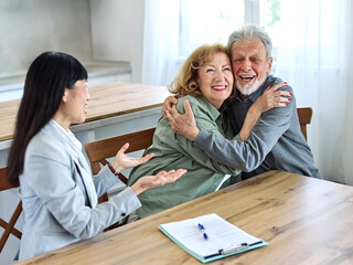 Happy senior old family couple clients make financial insurance estate business deal contract signing, agent lawyer businesswoman, satisfied mature customers signing contract meeting bank manager agre