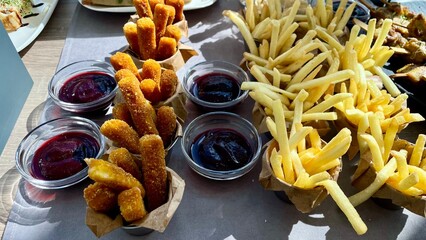 Appetizing Fried Snacks, Crispy French Fries and Cheese Sticks with Sauces for a Buffet