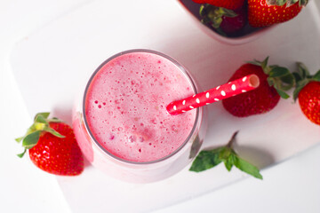 A glass of fresh strawberry smoothie on a white background. Summer drink shake, milkshake and refreshment organic concept.