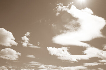  floating in the sky clouds with sun rays in sepia color view