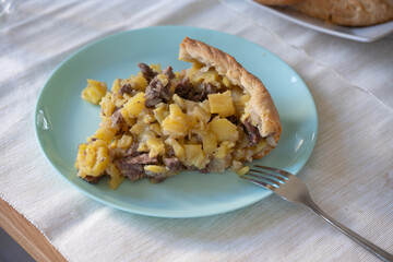 Serving of comforting meat pie with potatoes and onions filling enjoyed as hearty meal or snack,...