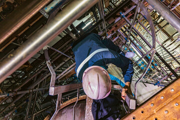 The topview male worker down the ladder is for inspection stainless steel tank © chitsanupong