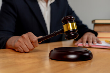 Selective focus on judge’s hand with gavel, symbolizing legal authority in business decision-making.