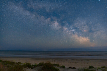 The Milky Way arches above a remote wild beach on the Black Sea coast, captured on a warm summer night free from light pollution – a serene astrophotography scene of stars, sea, and solitude