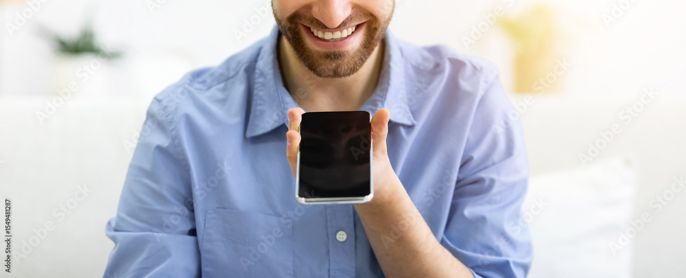 Poster voice assistant app. cheerful man using smartphone with voice search application sitting on couch at