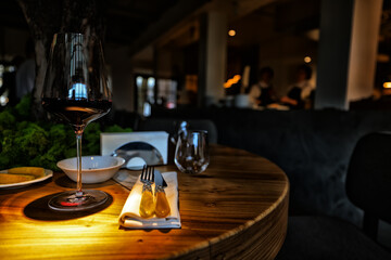 dinner in a restaurant with wine, beautiful table setting, a glass of wine in the foreground