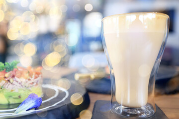 a cup of coffee on a summer morning, sideways sunlight and rays, blurred soft color background, bokeh
